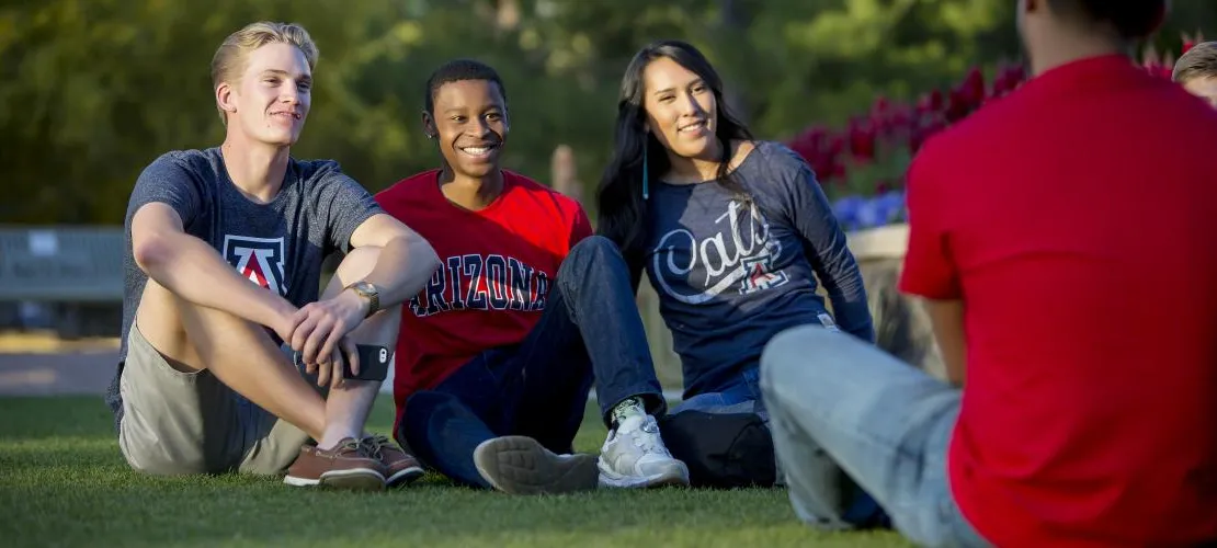 Three UA students sitting on grass